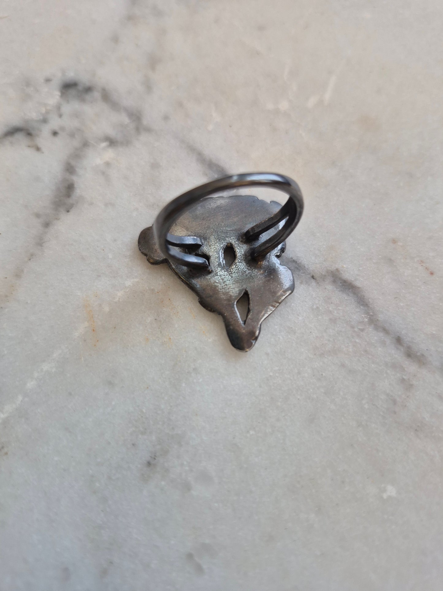 back of a silver ring on marble background