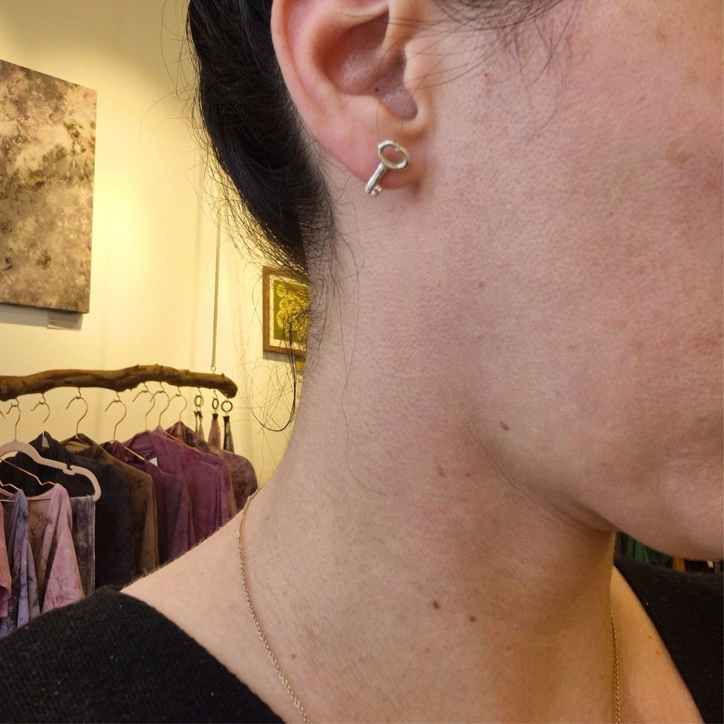Handmade silver key earrings on woman's ear by Alice Scott