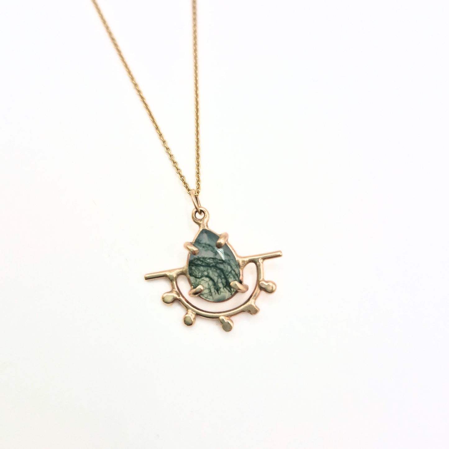 gold pendant on white background with moss agate stone by Alice Scott