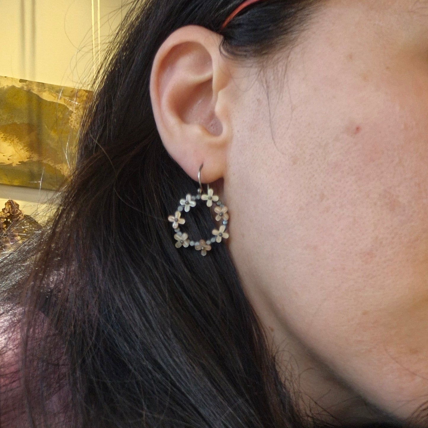 Close-up of an ear with a unique earring, hair partially covering the face by Alice Scott