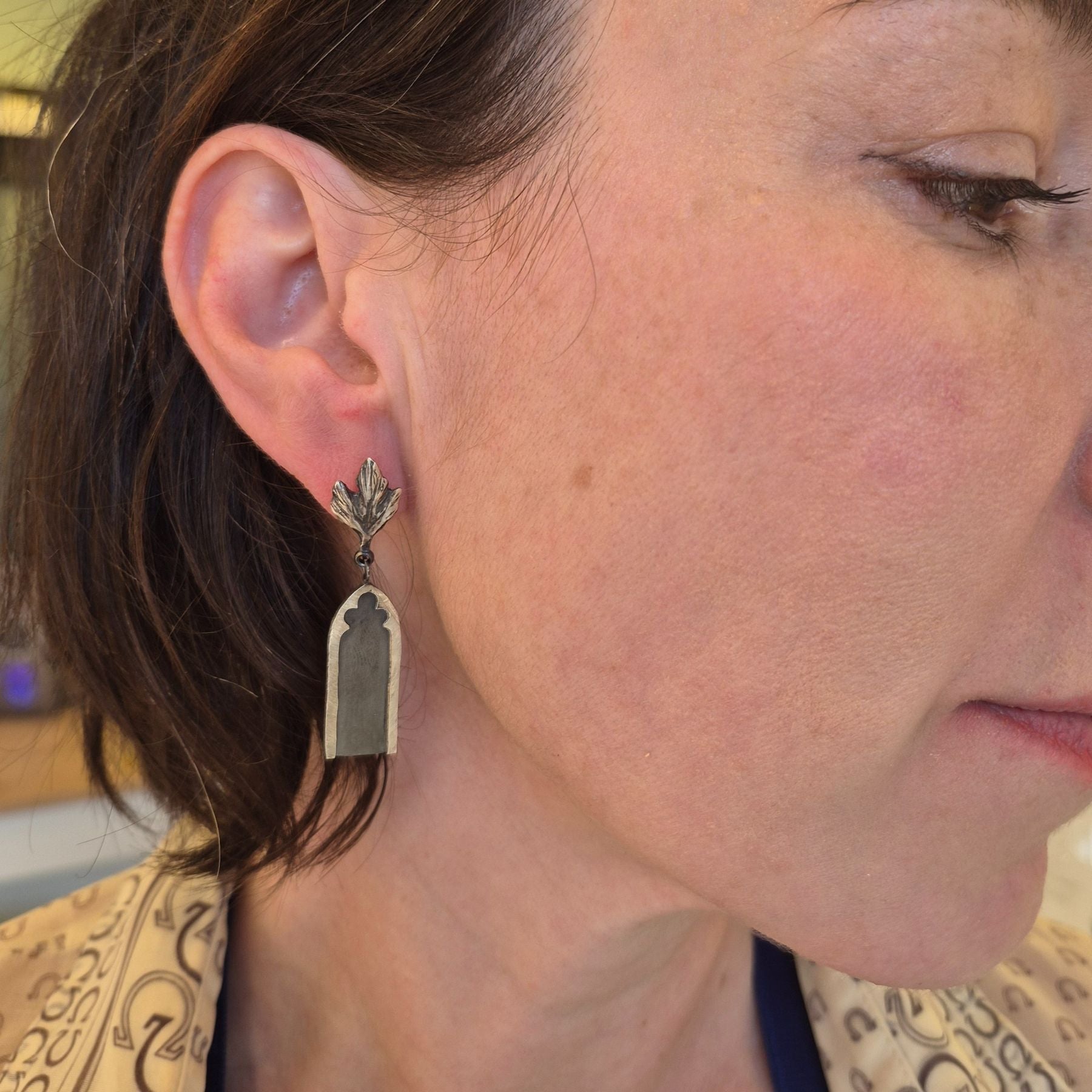 silver gothic arch earrings with silver leaves on ear closeup by Alice Scott