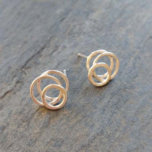A pair of silver posts with a circular galaxy design, placed on a stone surface.