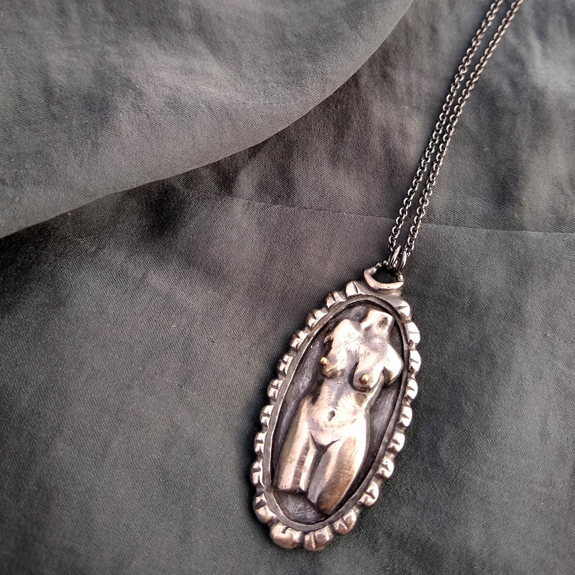 handmade Woman torso in sterling silver cameo pendant in sterling silver with black patina, on fabric background, by Alice Scott